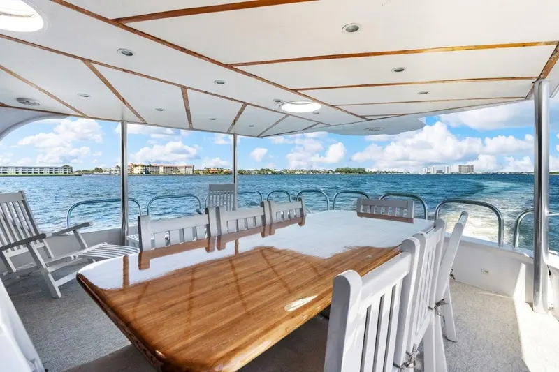 Envision's covered aft deck with a teak dining table and water views